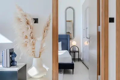 a bedroom with a bed and a vase with feathers at Sobha waves I Cozy 1BDR I Burj Khalifa View in Dubai