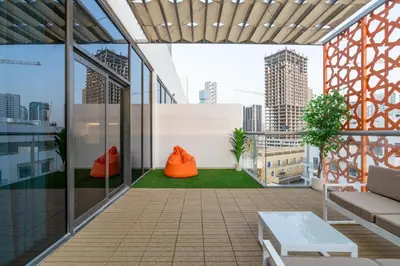 an office balcony with orange furniture and a view of the city at Upgraded Designer-crafted Studio in JVC with Massive Terrace in Dubai