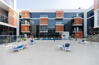 a courtyard of a building with blue chairs and buildings at Upgraded Designer-crafted Studio in JVC with Massive Terrace in Dubai
