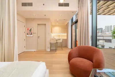 a bedroom with a bed and a chair at Upgraded Designer-crafted Studio in JVC with Massive Terrace in Dubai