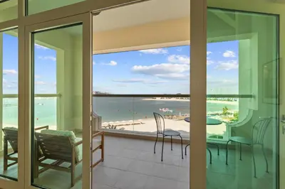 a balcony with a table and chairs and a view of the beach at Exquisite 1BR with Private beach in Palm Jumeirah in Dubai