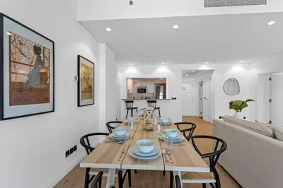 a dining room and living room with a table and chairs at Exquisite 1BR with Private beach in Palm Jumeirah in Dubai
