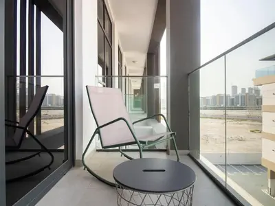 a room with a chair and a table on a balcony at Spacious 2BR with Big Balcony In Meydan in Dubai