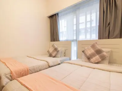 two beds in a room with a window at Spacious 2BR with Big Balcony In Meydan in Dubai