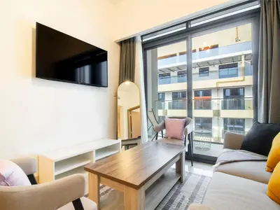 a living room with a table and a large window at Spacious 2BR with Big Balcony In Meydan in Dubai