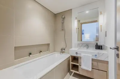 a bathroom with a tub and a sink and a mirror at New I Modern I 1BDR I 17 Icon Bay Tower 2 in Dubai