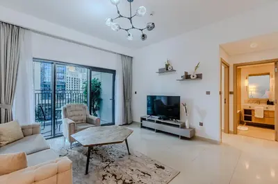 a living room with a couch and a table and a tv at New I Modern I 1BDR I 17 Icon Bay Tower 2 in Dubai