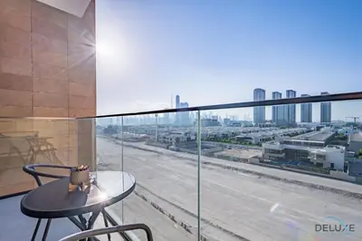 a balcony with a table and a view of a city at Delightful 1BR Apartment in Azizi Riviera 22, Al Merkadh by Deluxe Holiday Homes in Dubai