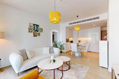 a living room with a white couch and tables at Palace Residences - Inviting One Bedroom in Dubai