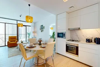 a kitchen and dining room with a table and chairs at Palace Residences - Inviting One Bedroom in Dubai