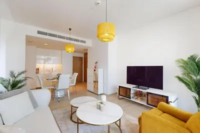 a living room with a white couch and a tv at Palace Residences - Inviting One Bedroom in Dubai