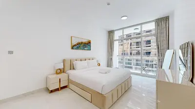 a white bedroom with a bed and a large window at Locations I Uni Estate Supreme Residence I Luxury 1BR I Near Miracle Garden I Pool, Gym & Parking in Dubai