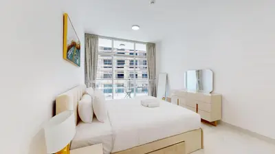 a white bedroom with a bed and a window at Locations I Uni Estate Supreme Residence I Luxury 1BR I Near Miracle Garden I Pool, Gym & Parking in Dubai