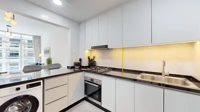 a kitchen with white cabinets and a washer and dryer at Locations I Uni Estate Supreme Residence I Luxury 1BR I Near Miracle Garden I Pool, Gym & Parking in Dubai