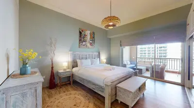 a bedroom with a large bed and a balcony at Golden Mile 1 - Contemporary One Bedroom in Dubai