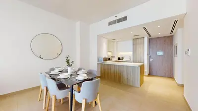 a dining room with a table and chairs and a kitchen at Liv Residences - Spacious Two Bedroom in Dubai