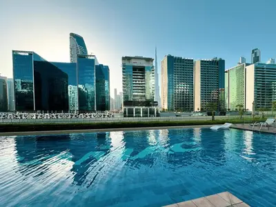 a swimming pool with a city skyline in the background at LUXE | 1BR | Close to Burj Khalifa & Dubai Mall in Dubai
