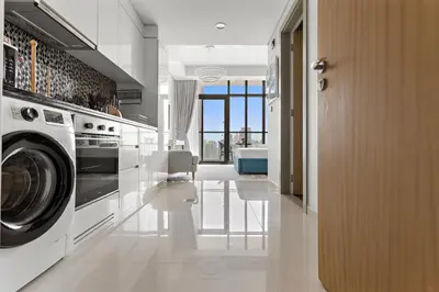 a kitchen with a washer and dryer in a room at Lush studio with Pool & Dubai Water Canal Views in Dubai