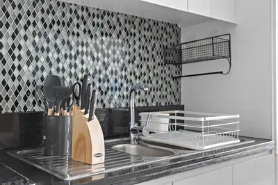 a kitchen counter with a sink and a dish rack at Lush studio with Pool & Dubai Water Canal Views in Dubai