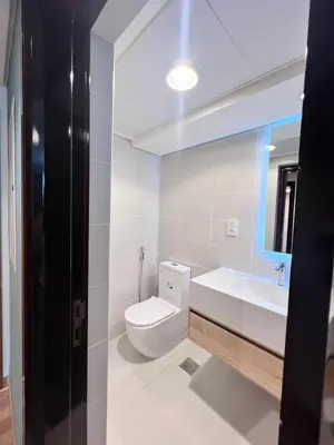 a white bathroom with a toilet and a sink at Luxurious 1BR in Burj Views Podium, Downtown in Dubai