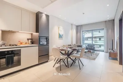 a kitchen and dining room with a table and chairs at Manzil - 1BR Apartment in Marquis Signature with City Views in Dubai