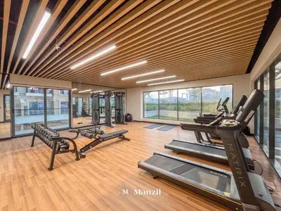 a gym with treadmills and elliptical machines and windows at Manzil - 1BR Apartment in Marquis Signature with City Views in Dubai