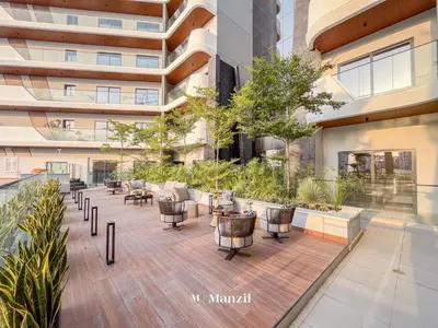an outdoor patio with tables and chairs in a building at Manzil - 1BR Apartment in Marquis Signature with City Views in Dubai