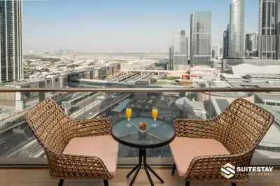 a table and chairs on a balcony with a view of a city at Emaar Residence Fashion Avenue in Dubai