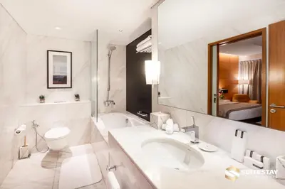 a bathroom with a sink and a toilet and a mirror at Emaar Residence Fashion Avenue in Dubai