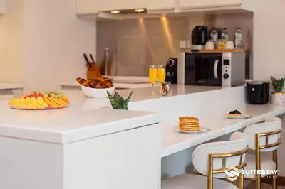 a kitchen with a counter with a bowl of fruit and drinks at Emaar Residence Fashion Avenue in Dubai