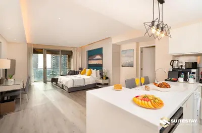 a kitchen and living room with a bed in a room at Emaar Residence Fashion Avenue in Dubai