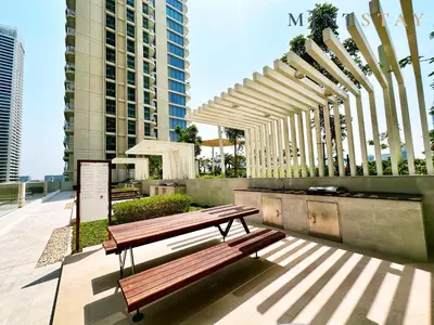 a wooden bench sitting on top of a patio at Marina Vista 2, Emaar Beachfront - Mint Stay in Dubai