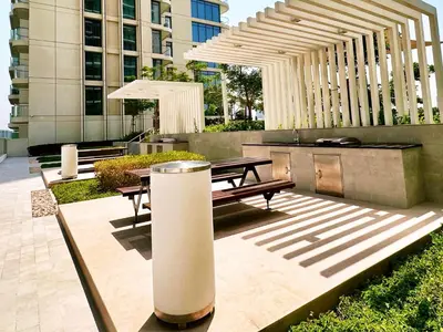 a patio with a picnic table and an umbrella at Marina Vista 2, Emaar Beachfront - Mint Stay in Dubai