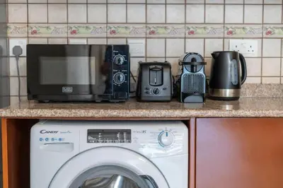 a kitchen counter with a washing machine and a microwave at Peaceful flat in Motor City in Dubai