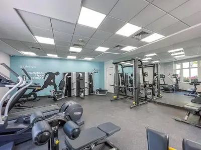 a gym with several tread machines in a room at Peaceful flat in Motor City in Dubai