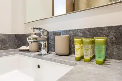 a bathroom counter with four bottles of moisturizers and a sink at Waves - 52 42 Emaar, Tower 1 in Dubai