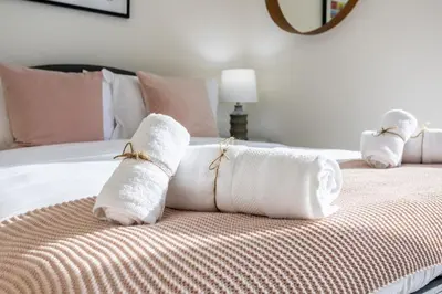 two white towels on a bed in a bedroom at Waves - 52 42 Emaar, Tower 1 in Dubai