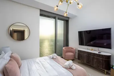 a bedroom with a bed with a mirror and a tv at Waves - 52 42 Emaar, Tower 1 in Dubai