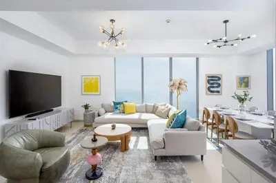 a living room with a couch and a tv at Waves - 52 42 Emaar, Tower 1 in Dubai