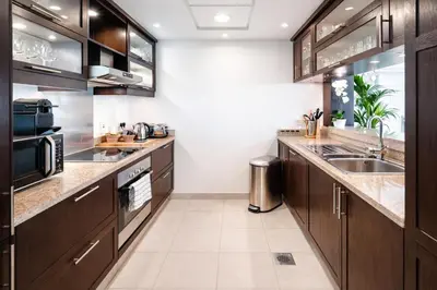 a kitchen with wooden cabinets and a sink at Elite Royal Apartment - Full Burj Khalifa & Fountain View - Luxurious - Viceroy in Dubai