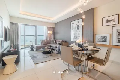 a living room with a dining table and a couch at Manzil - 1BR Apartment in Paramount with Top-Floor Luxury Living in Dubai