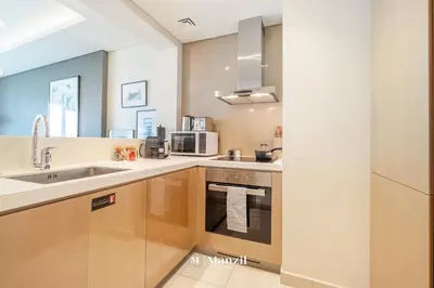 a kitchen with a sink and a microwave at Manzil - 1BR Apartment in Paramount with Top-Floor Luxury Living in Dubai