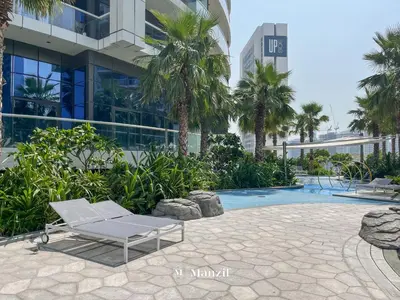 a chaise lounge sitting in front of a building at Manzil - 1BR Apartment in Paramount with Top-Floor Luxury Living in Dubai