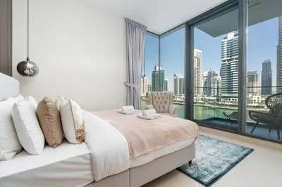 a bedroom with a large window with a view of the city at Vacay Lettings - Liv Residence in Dubai