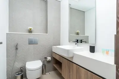 a bathroom with a toilet and a sink and a mirror at Vacay Lettings - Liv Residence in Dubai