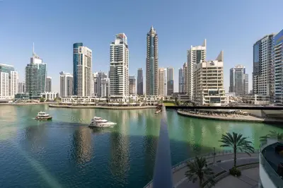 a river with boats in a city with tall buildings at Vacay Lettings - Liv Residence in Dubai