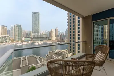 a balcony with chairs and a view of the city at Maison Privee - Cosmopolitan Apt with Scenic Dubai Marina Vws in Dubai