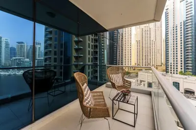 a balcony with two chairs and a table at Maison Privee - Cosmopolitan Apt with Scenic Dubai Marina Vws in Dubai