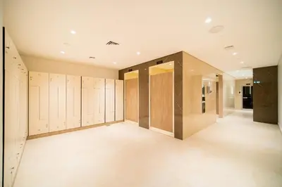 a large dressing room with wooden doors and tile floors at SettlerHomes - Upscale JLT Stay Near Metro in Dubai