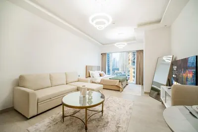 a living room with a couch and a table at SettlerHomes - Upscale JLT Stay Near Metro in Dubai